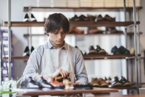 Young man shoeshiner polishing shoes