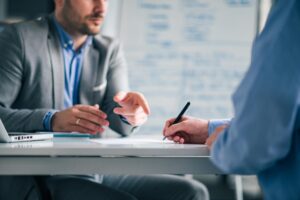 Business people negotiating, signing a contract, close-up.