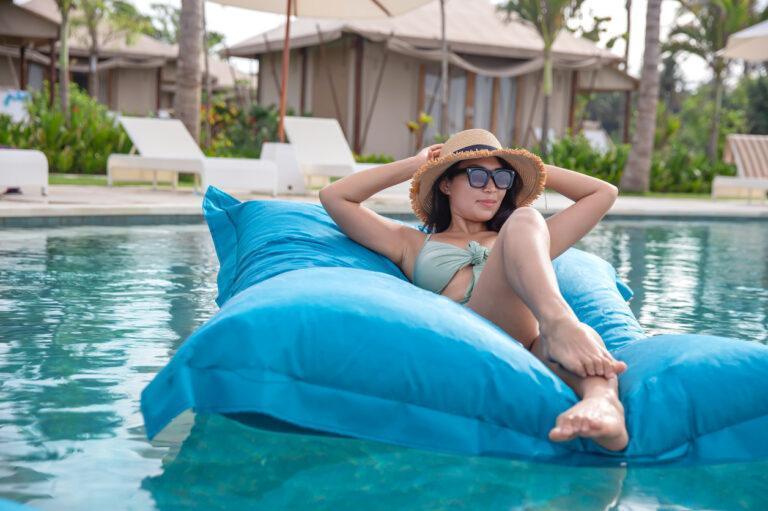Beautiful Southeast Asian Woman Relaxing on Floating Pool Bean Bag
